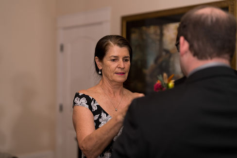 Woman in floral dress looking at man at an indoor event.