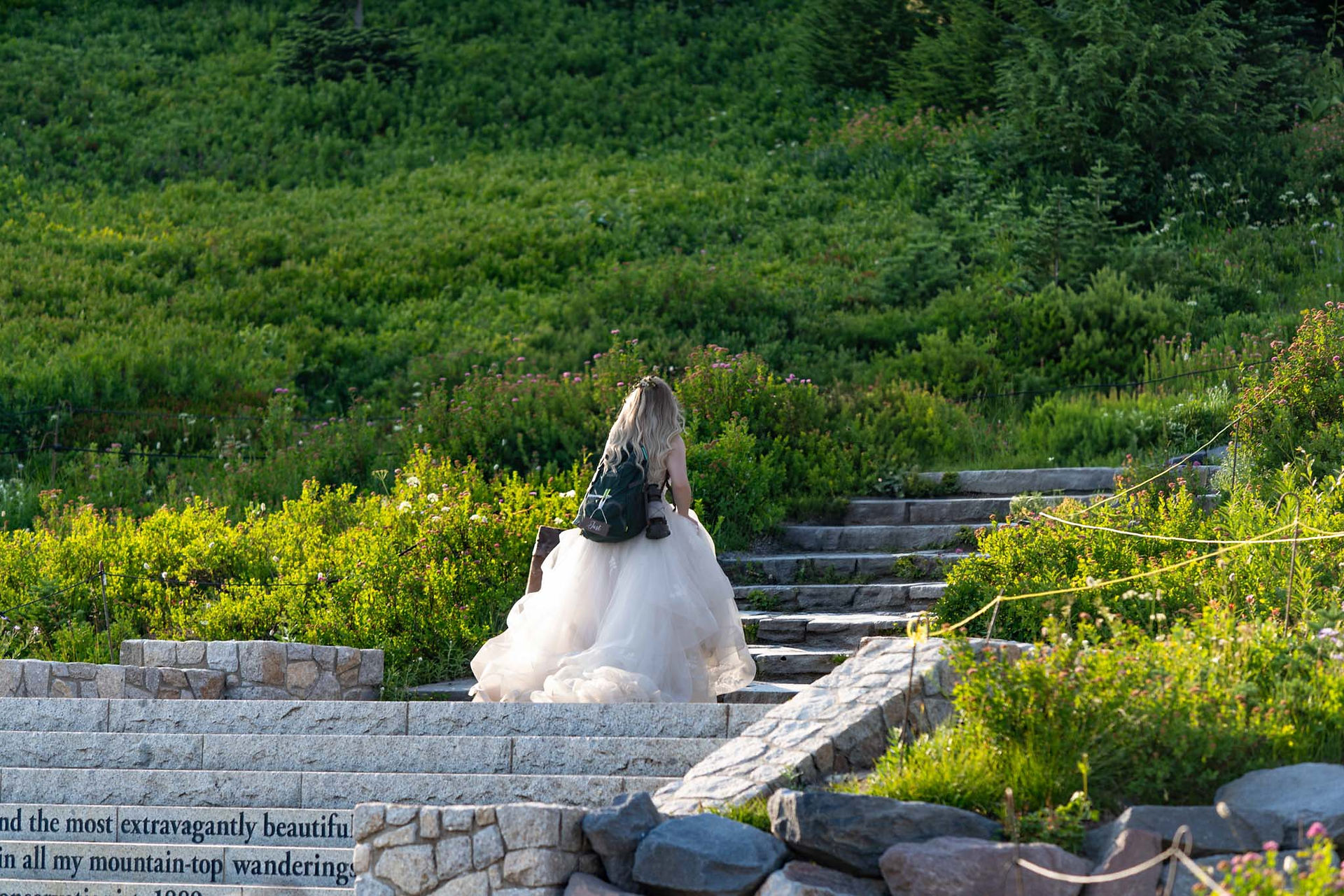 Bride in white wedding dress climbing outdoor stone steps