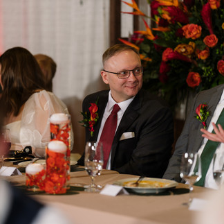Smiling man in suit at Bastyr Chapel Wedding reception table.