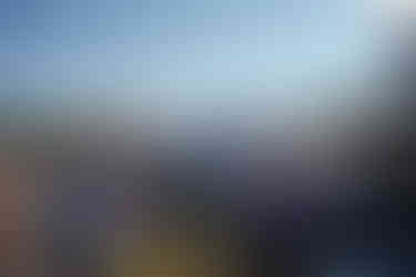 Man in blue suit walks past seated guests at intimate farm wedding.