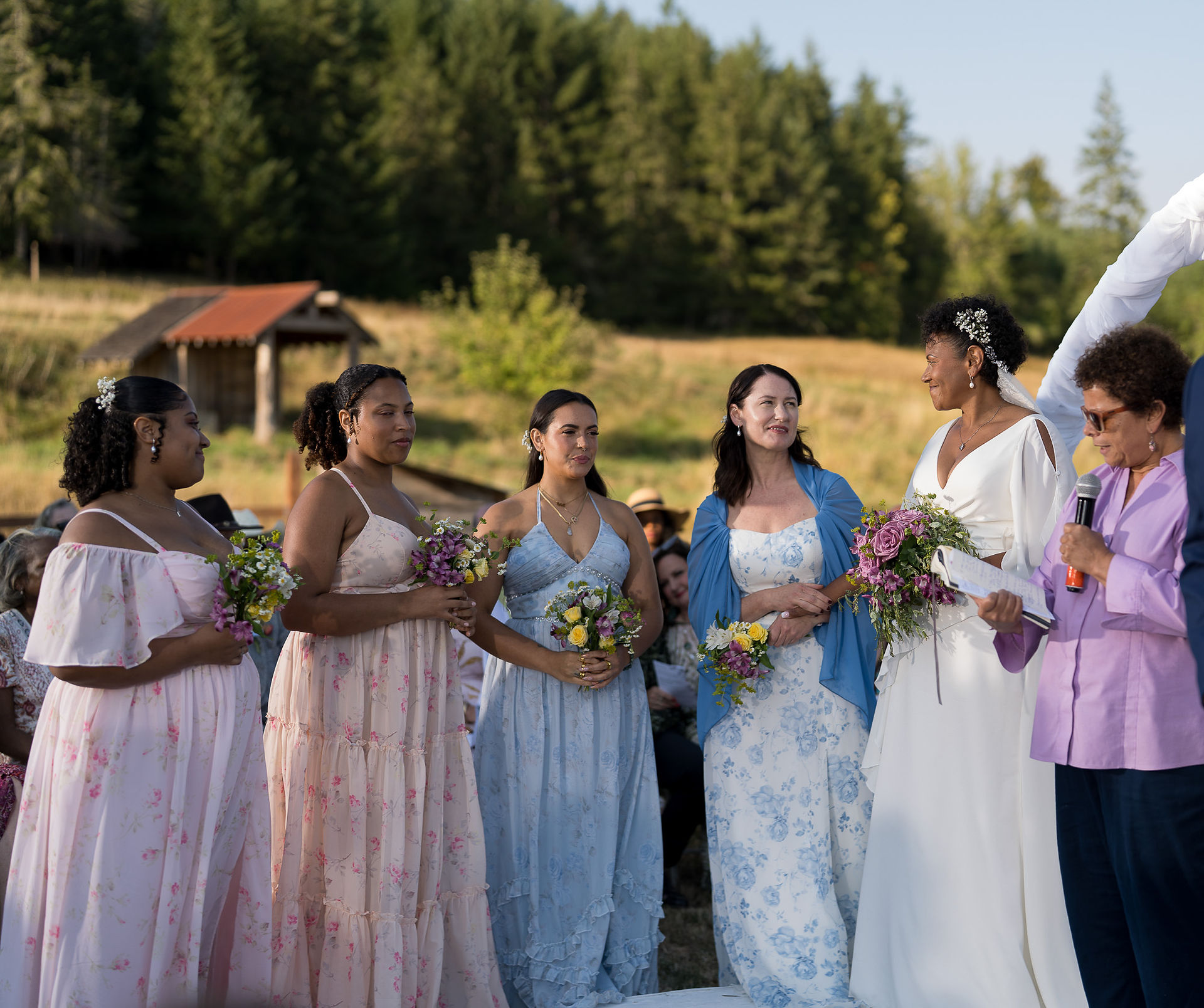 Bride and bridesmaids holding bouquets at an intimate farm wedding.