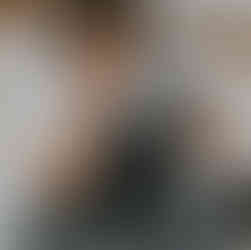 Smiling young boy holds large professional camera with telephoto lens.