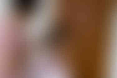 Woman getting pearl hair accessory placed in her curly hair, smiling.