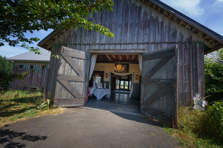 Rustic barn open doors reveal wedding reception interior at Chehalis WA.