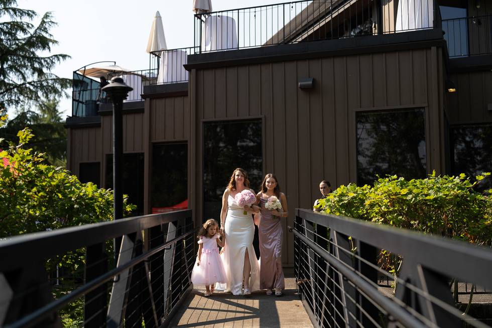 Bride, bridesmaid, flower girl walking on bridge at The Foundry wedding.