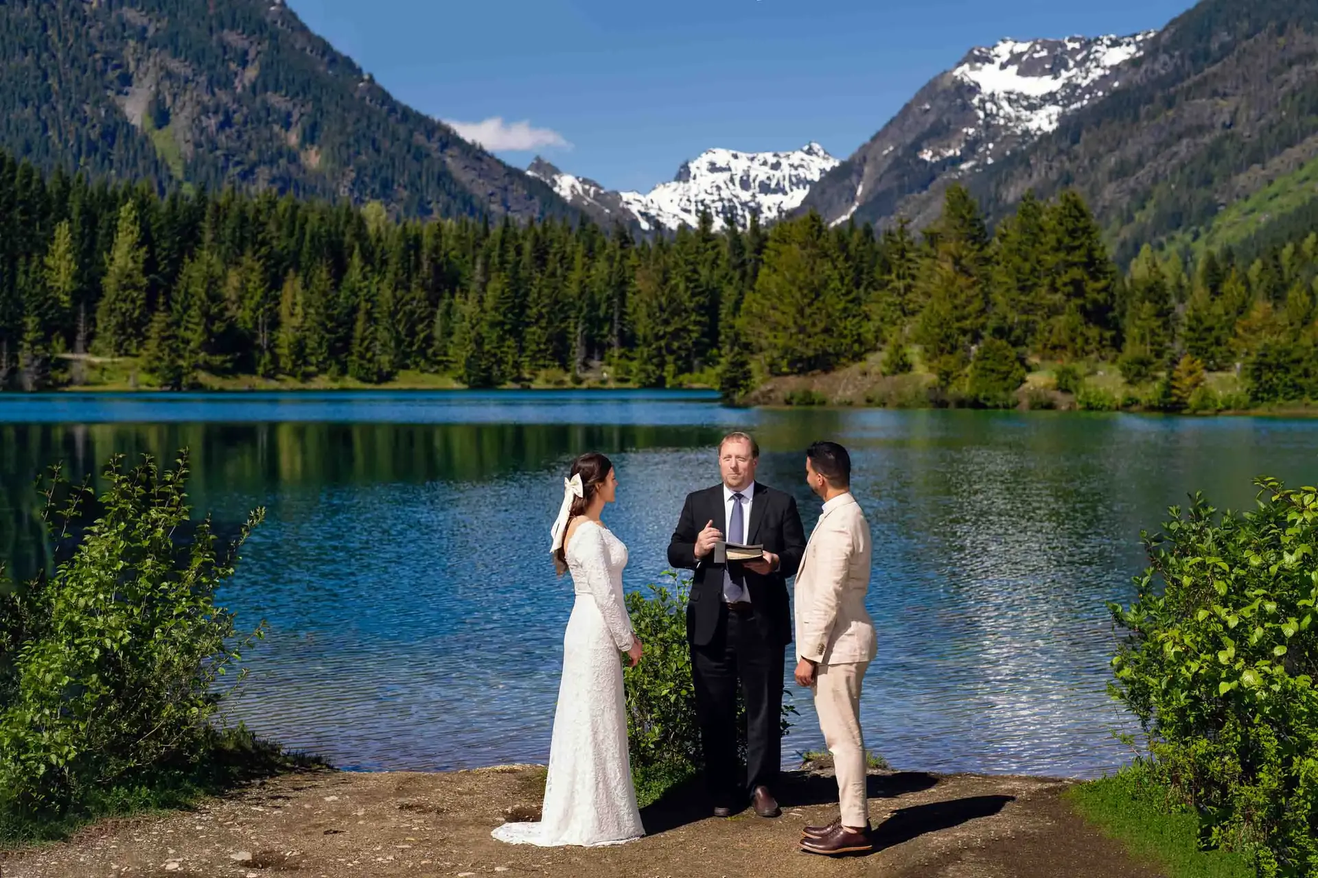 Couple exchanging vows during a scenic outdoor wedding ceremony by a lake