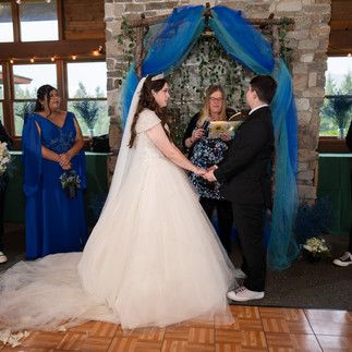 Bride, groom, and officiant at a Gold Mountain Golf Club wedding ceremony