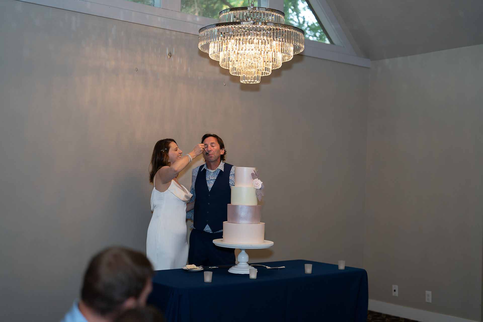 Bride and groom feed wedding cake at elegant Foundry reception.