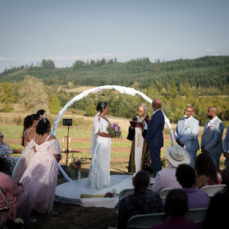Couple exchanges vows with officiant during an outdoor intimate farm wedding.
