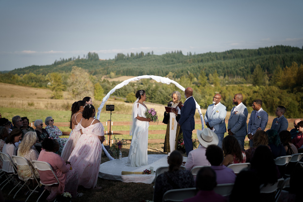 Couple exchanges vows with officiant during an outdoor intimate farm wedding.