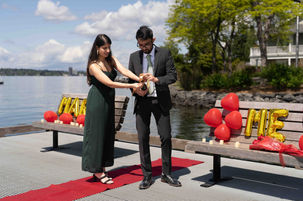 Couple at Medina Beach proposal, "Marry Me" sign