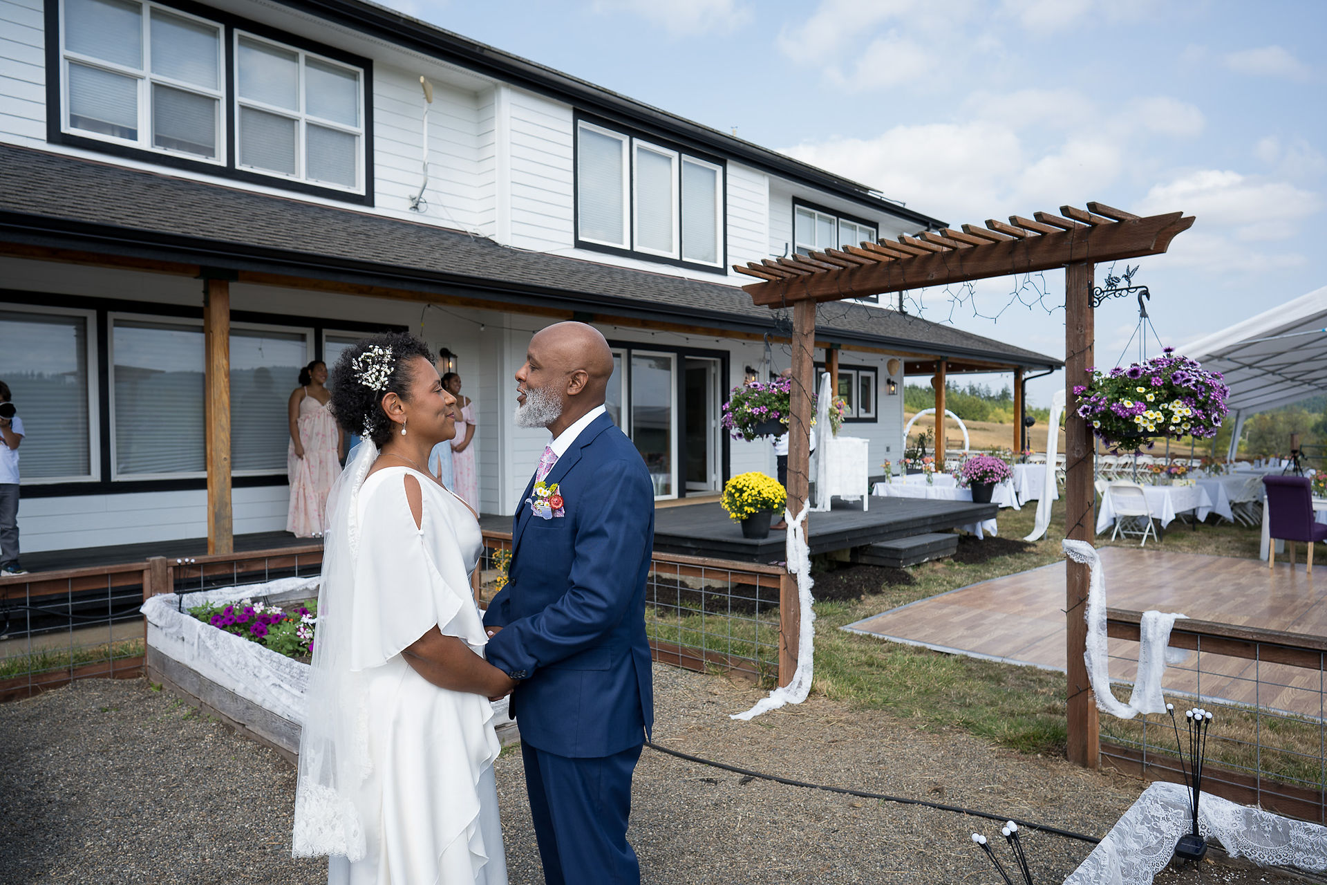 Bride and groom holding hands at outdoor farm wedding ceremony.