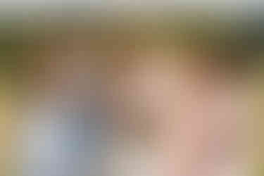 Happy bride and four bridesmaids holding colorful bouquets at outdoor celebration.