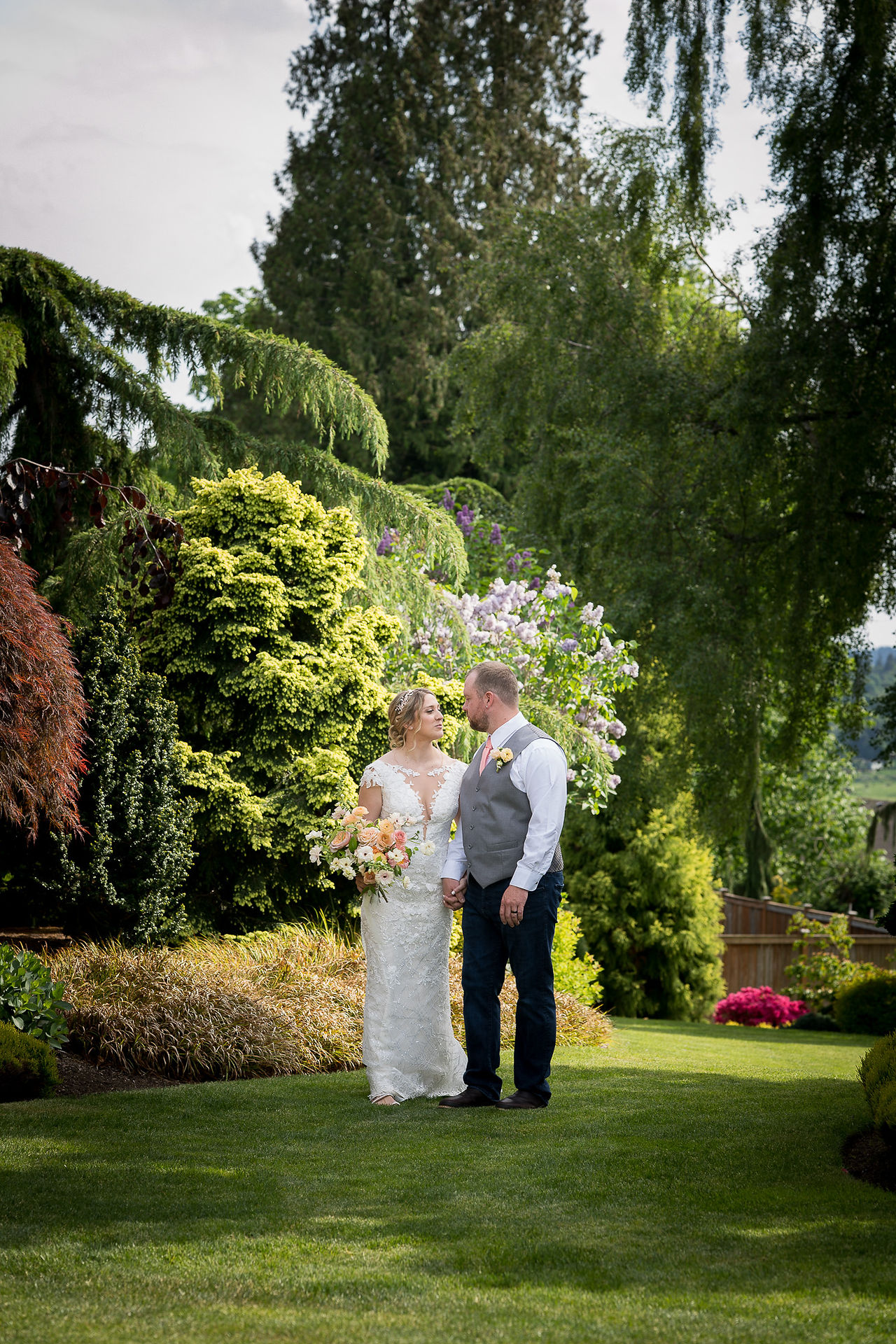 Romantic bride and groom holding hands in a stunning outdoor garden.