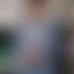 Person in blue suit adjusts cuff near "Wifi" sign.