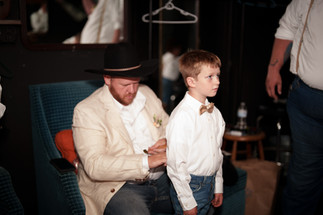 Man in hat adjusts boy's bow tie for Chehalis WA wedding.