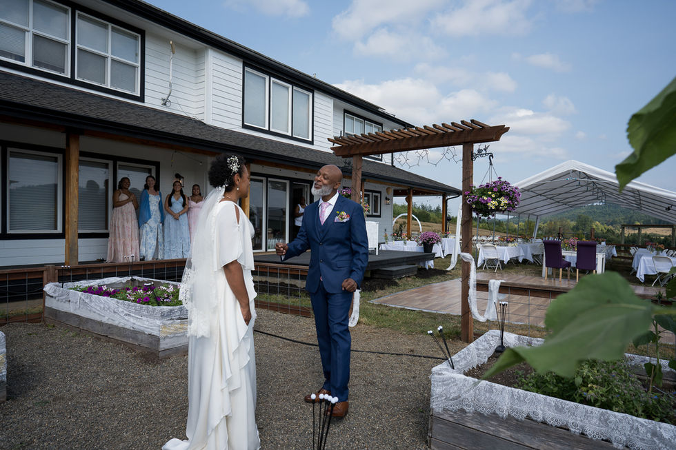 Bride and man talking at an intimate outdoor farm wedding.