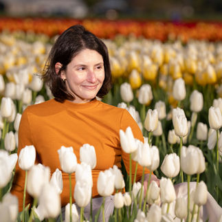 Smiling woman surrounded by white tulips, Skagit Tulip Festival.