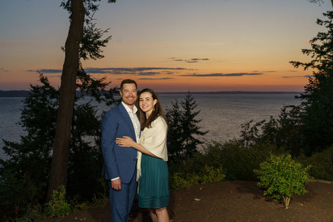 Happy couple embracing by scenic ocean sunset.