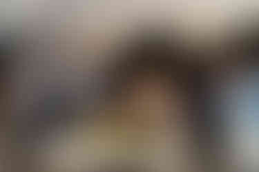 Couple and guests celebrate around floral table at intimate farm wedding.