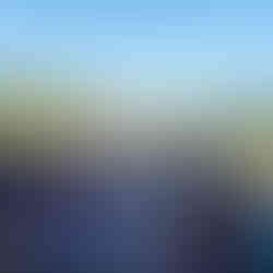 Outdoor wedding ceremony with guests under arch, rolling hills background.