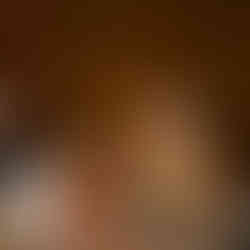 Woman smiling, talking at a reception table with a man.