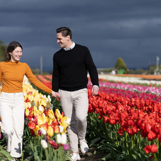 Smiling couple walks through tulips at Skagit Tulip Festival