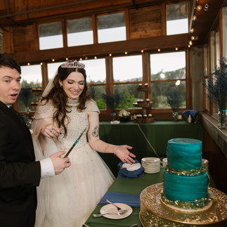 Couple cuts teal wedding cake at Gold Mountain Golf Club Weddings
