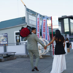 Romantic Seattle boat proposal: Man with roses, woman in black dress
