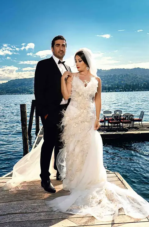 Elegant bride and groom standing on a wooden pier by the lake.