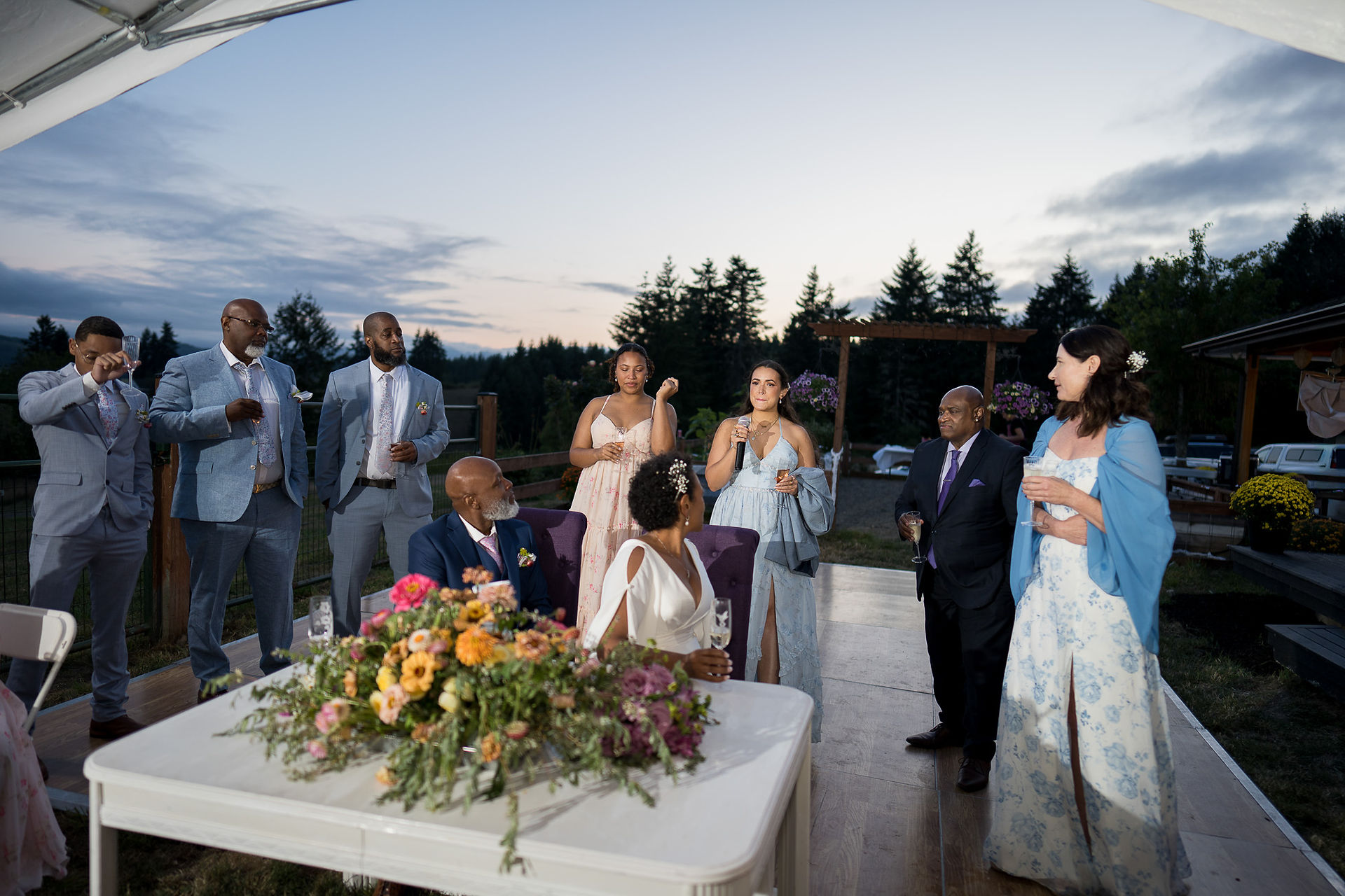Celebrating couple and guests at an intimate outdoor evening farm wedding.