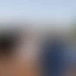 Bride and groom exchanging rings at outdoor wedding ceremony with officiant.