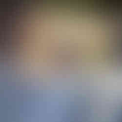 Elegant woman in white dress looks forward at intimate outdoor wedding.