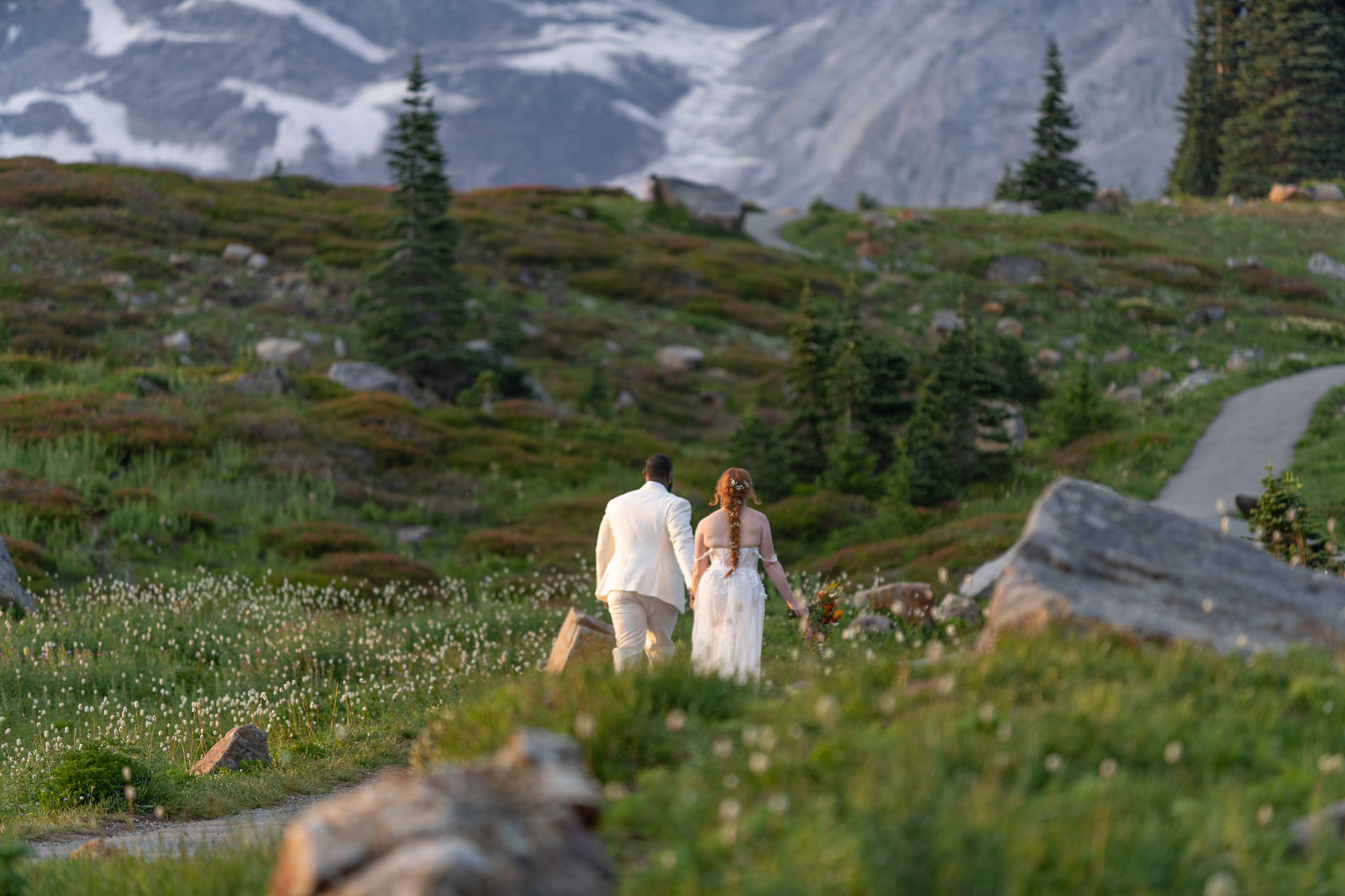 Couple holding hands, walking away mountain background