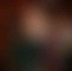 Joyful couple slow dancing at a wedding reception with bokeh string lights.