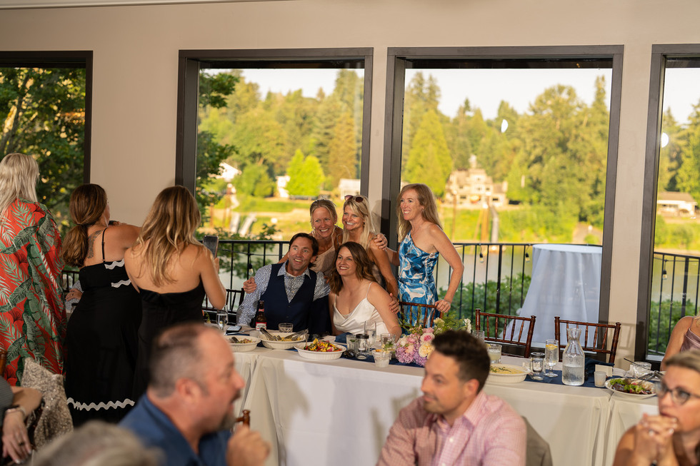 Happy wedding guests at table overlooking lake at The Foundry Oregon.