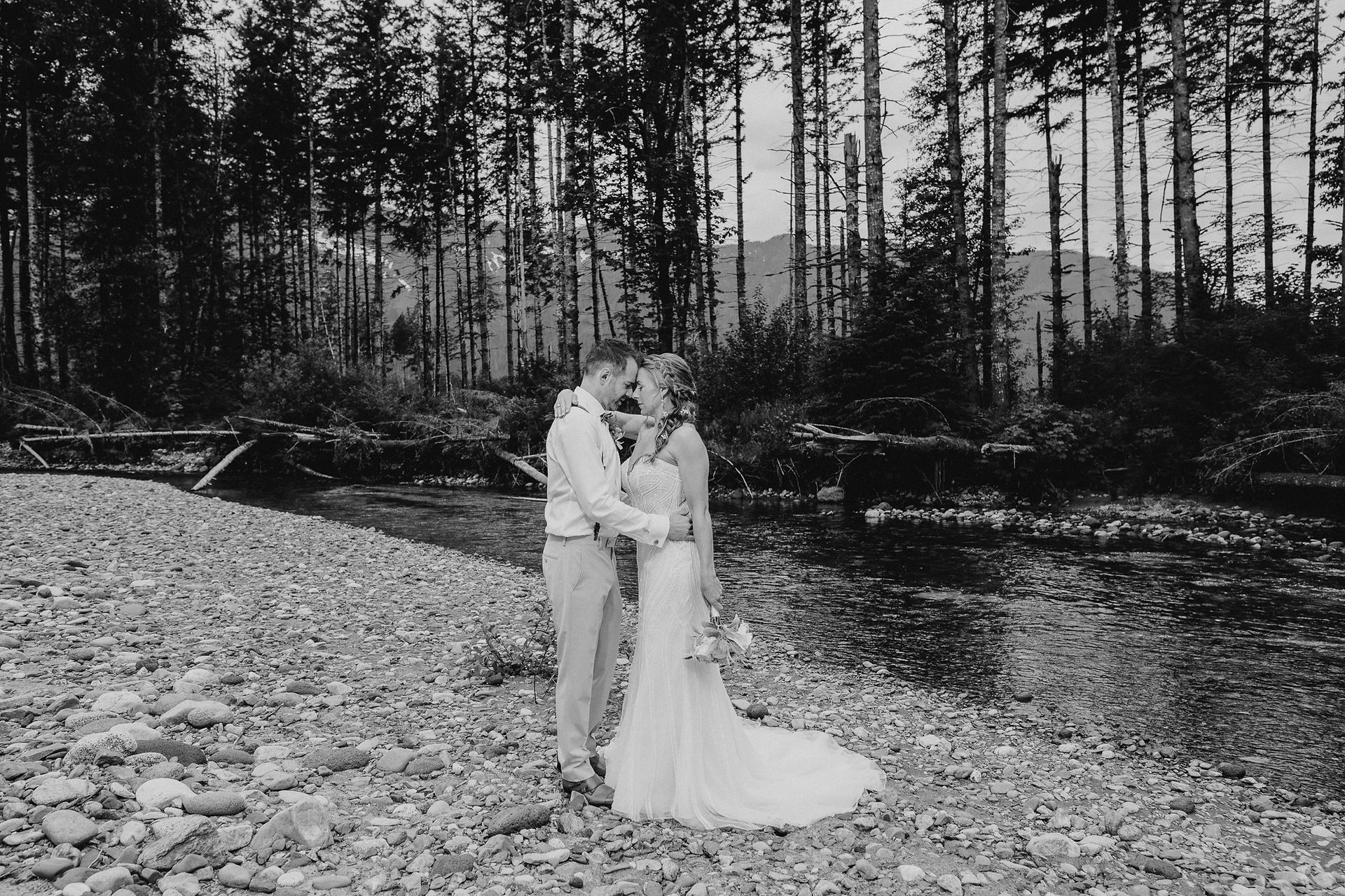 Bride and groom by the river at Forest Creek Darrington WA