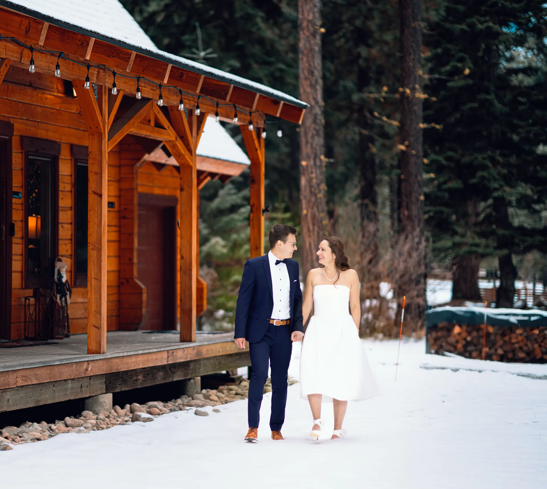 Happy couple strolls near snowy cabin