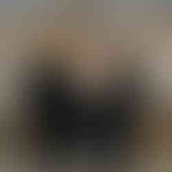 Bride, groom, and family pose under a white tent with string lights.