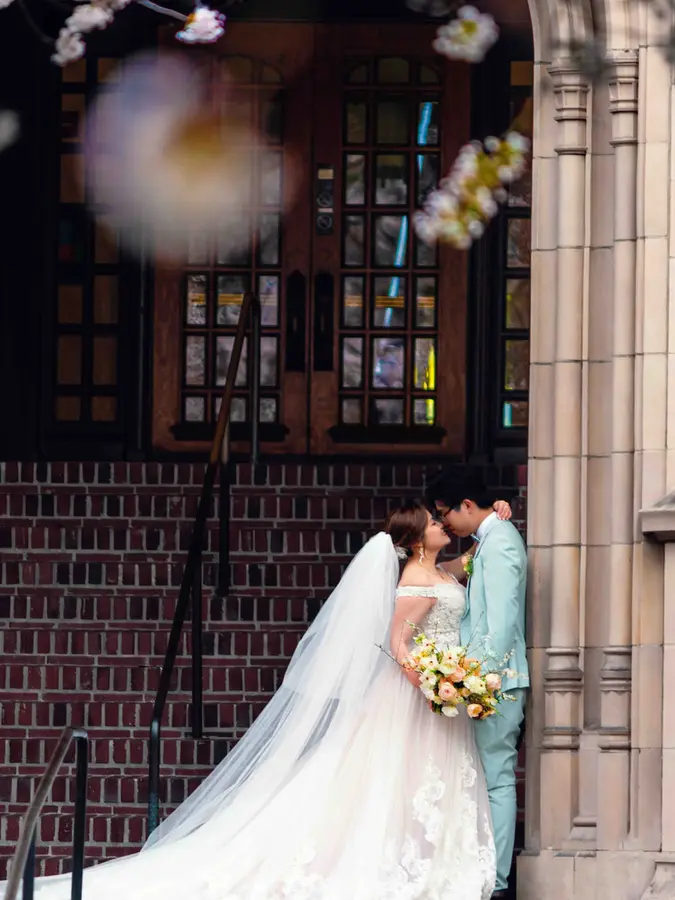 Bride and groom kissing near church