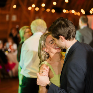 Happy couple dancing intimately at a warmly lit wedding reception.