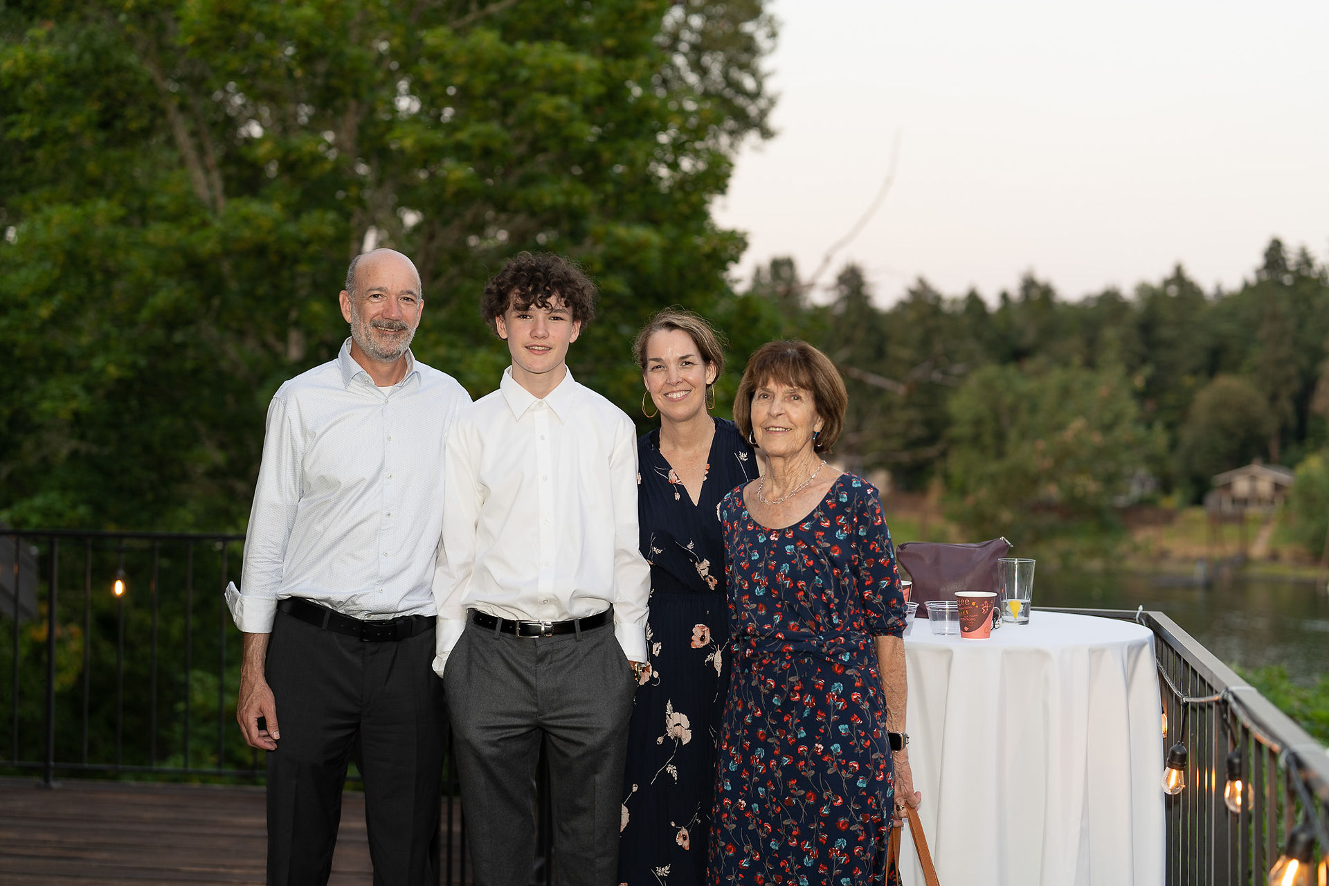 Family of four smiling, posing outdoors during an evening event.