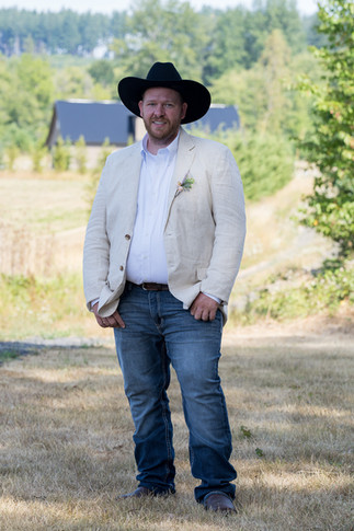 Man in black hat, beige jacket, jeans, at Barn on Jackson Chehalis, WA.