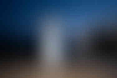 Happy wedding couple dancing on an outdoor wooden floor at twilight.