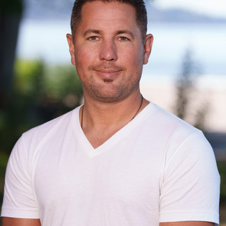 Headshot of man in white v-neck shirt