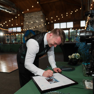 Man signing guest book at Gold Mountain Golf Club wedding