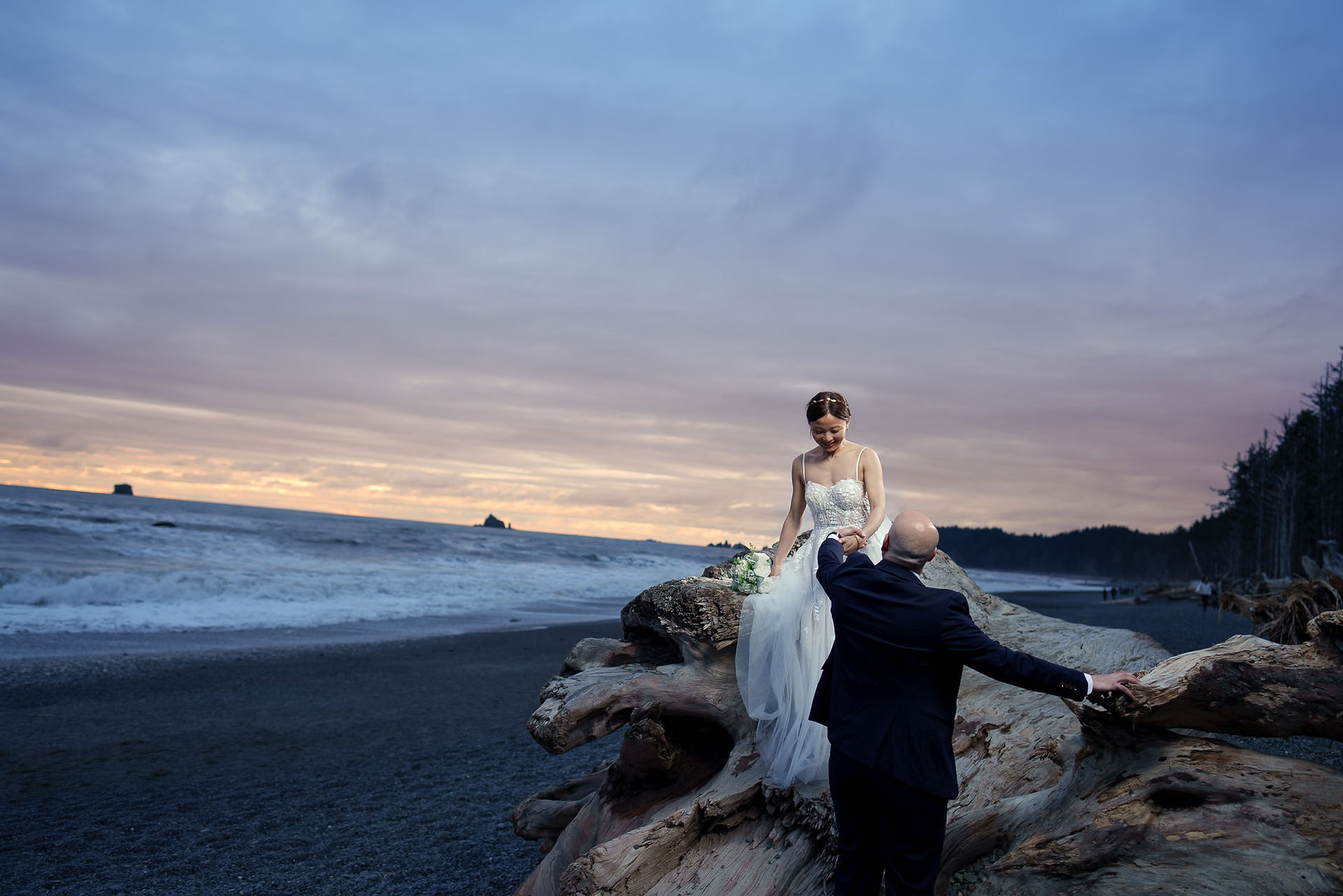 Elopement couple on driftwood at Ruby Beach, Olympic National Park.