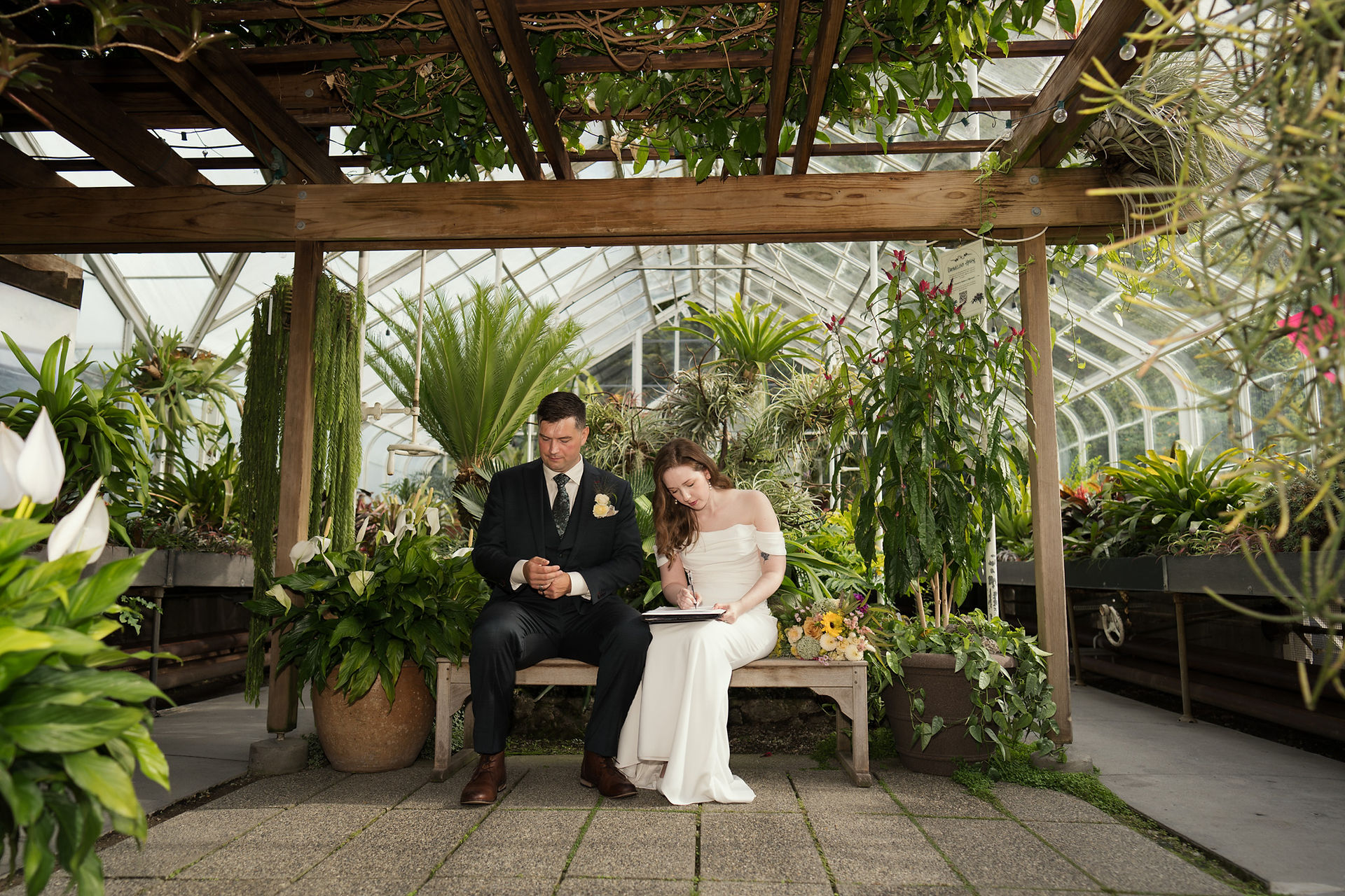 Couple signs marriage license at Volunteer Park Conservatory in Seattle.