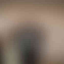 Man in suit and green tie dancing at wedding reception.