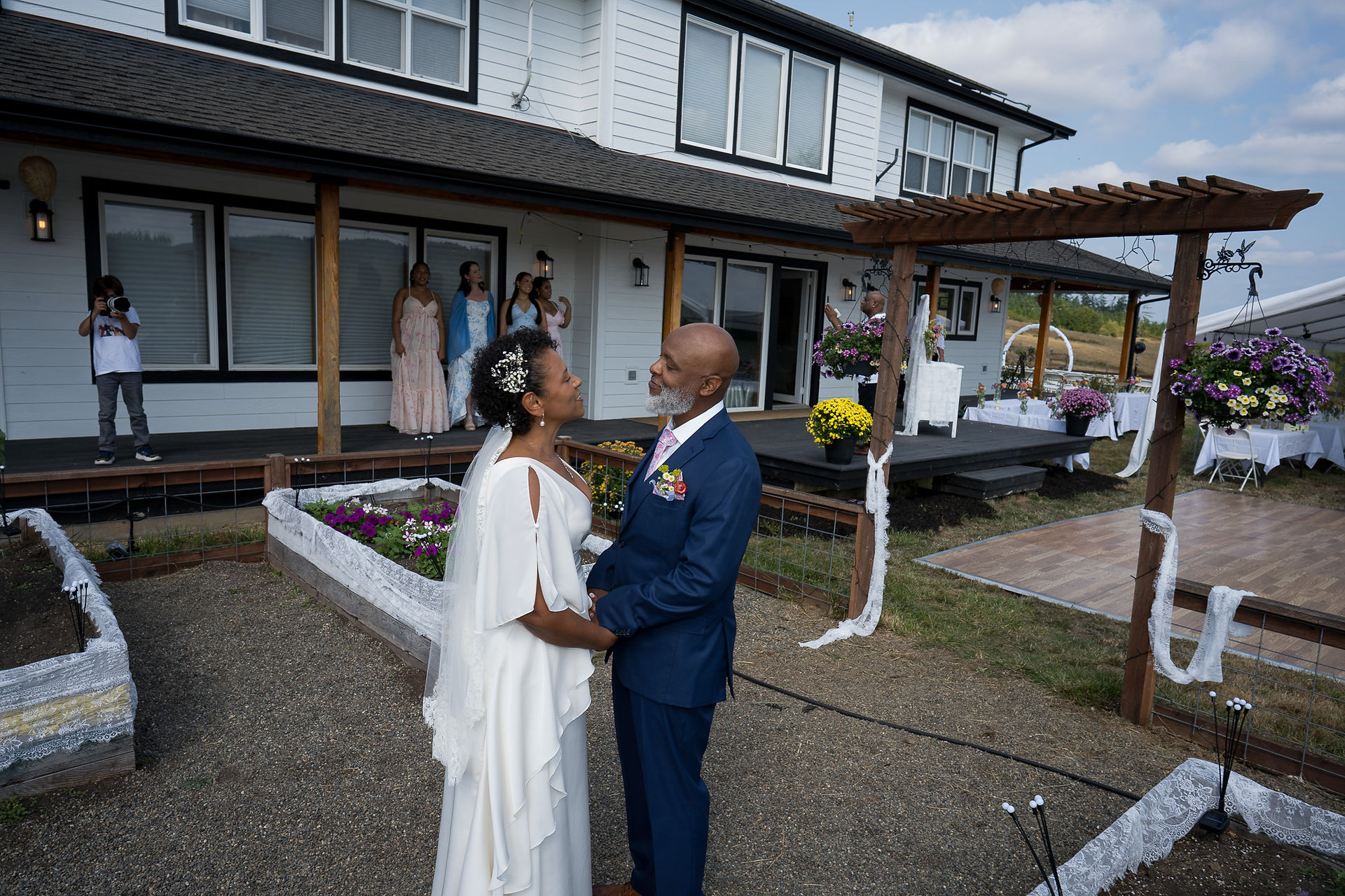 Bride and groom holding hands, exchanging vows at outdoor farm wedding.
